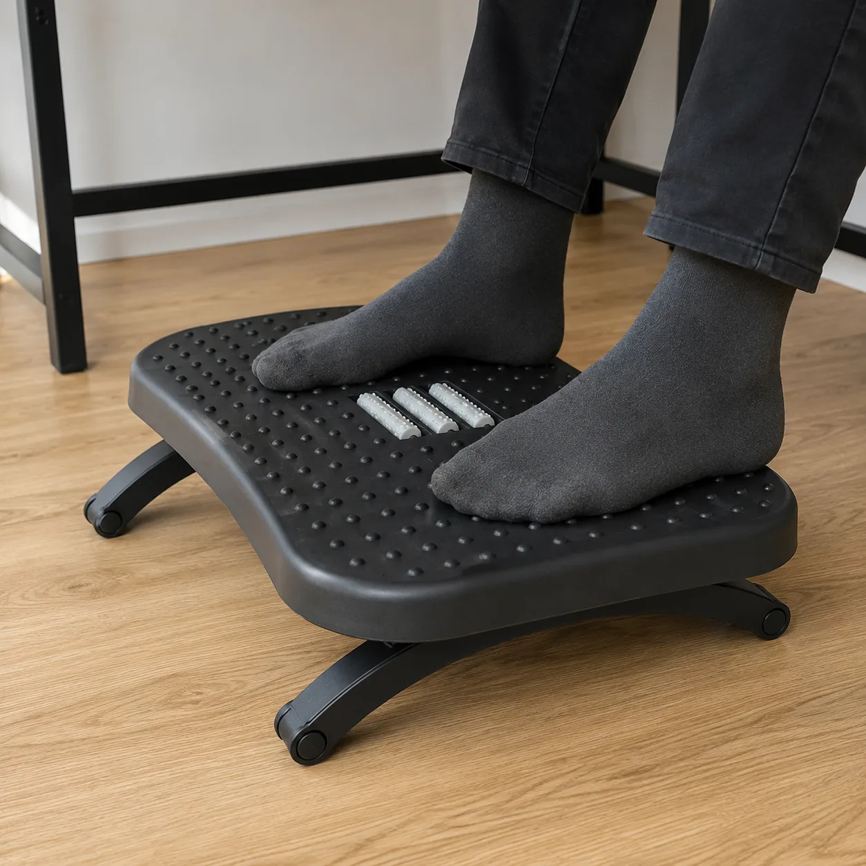 Main poussant le repose-pied ergonomique sur le côté pour éprouver sa stabilité au sol