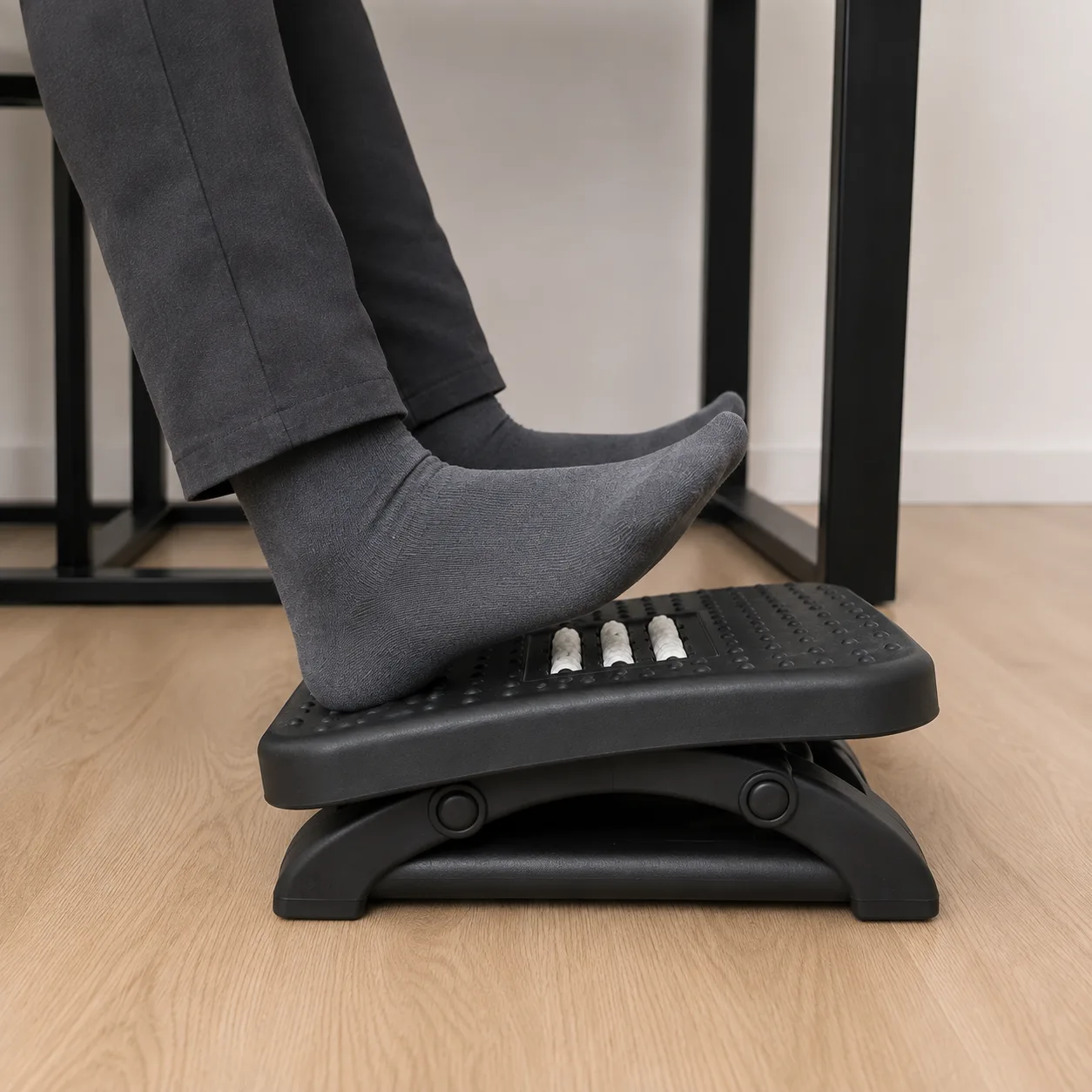Deux repose-pieds ergonomiques côte à côte, l’un réglé bas et l’autre haut, vus de profil