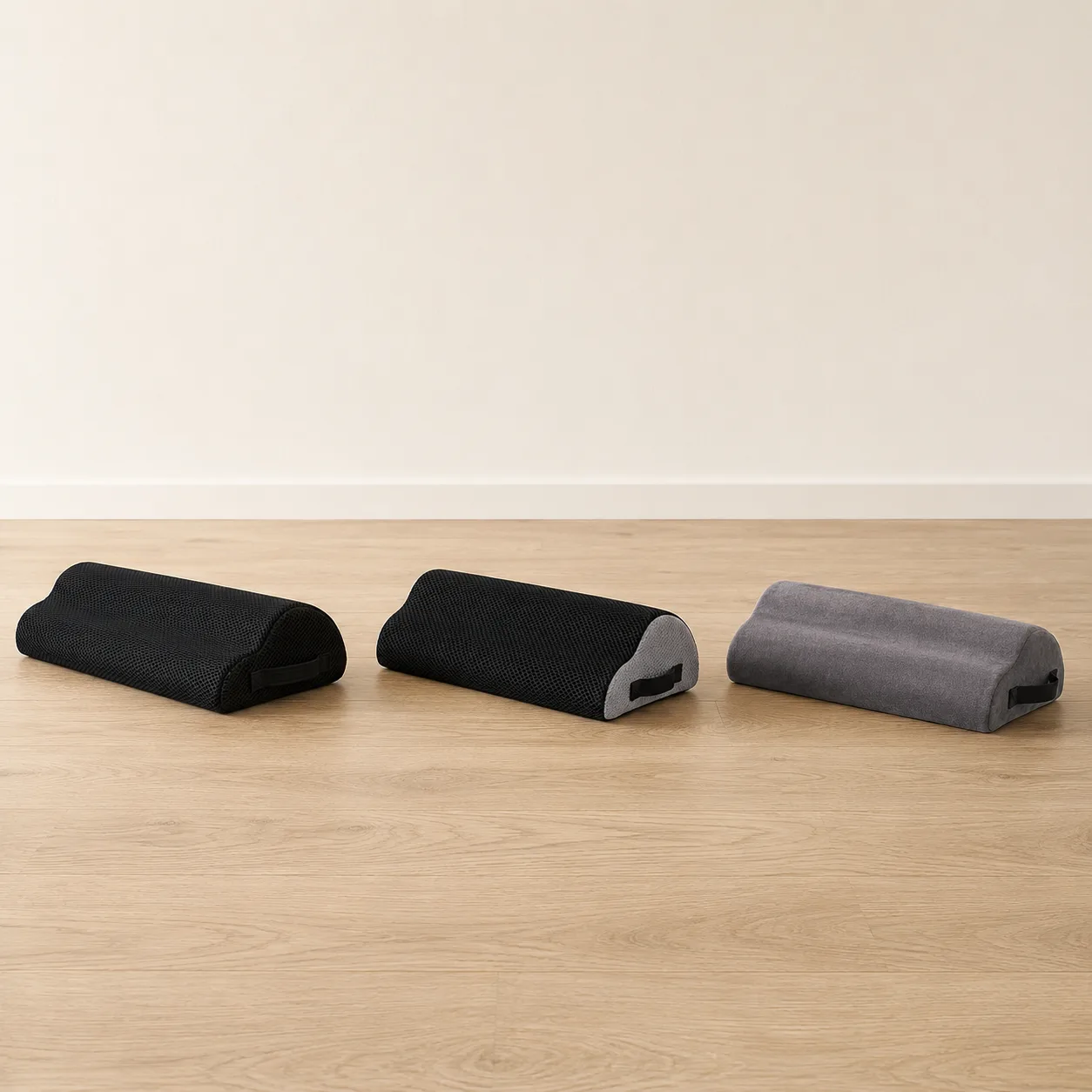 Les trois coloris du coussin repose-pied alignés : noir maille, noir cendré et gris foncé velours